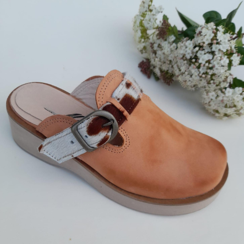 Zuecos de cuero con hebilla y detalle en diseño de vaca